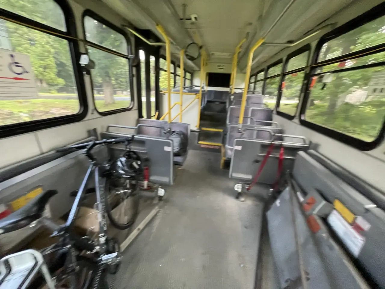 Looking down the aisle of the bus interior with a bicycle strapped in the wheelchair bay